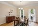 Bright dining room with hardwood floors and crown molding, offering a sophisticated space for dining and entertaining at 5100 Sunset Maple Trl, Lilburn, GA 30047