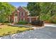 Beautiful two-story brick home with a well-manicured lawn and mature trees, creating a welcoming curb appeal at 5100 Sunset Maple Trl, Lilburn, GA 30047