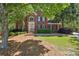 Charming brick home featuring manicured landscaping and mature trees, offering a picturesque and inviting setting at 5100 Sunset Maple Trl, Lilburn, GA 30047