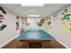 A fun game room with a table tennis table surrounded by wall art featuring college mascots at 5100 Sunset Maple Trl, Lilburn, GA 30047