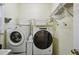 Functional laundry room with washer, dryer, and shelving for storage at 5100 Sunset Maple Trl, Lilburn, GA 30047