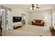 Comfortable living room with soft carpeting and a view of another room with great natural light and brown leather sofa at 5100 Sunset Maple Trl, Lilburn, GA 30047
