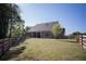 Expansive backyard with a fenced perimeter, lush grass, mature trees, and a shed at 6165 Namon Wallace Dr, Cumming, GA 30028
