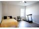 Bright bedroom featuring hardwood floors, a ceiling fan, and a large window with natural light at 6165 Namon Wallace Dr, Cumming, GA 30028