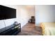 Comfortable bedroom with hardwood floors and TV; ideal for relaxing and working from home at 6165 Namon Wallace Dr, Cumming, GA 30028