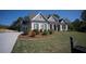 Beautiful home showcasing a well-manicured lawn, elegant landscaping, and a welcoming front porch at 6165 Namon Wallace Dr, Cumming, GA 30028