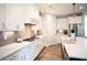 Modern white kitchen with stainless steel appliances, quartz countertops, and stylish pendant lighting at 6165 Namon Wallace Dr, Cumming, GA 30028