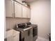 Well-organized laundry room with modern washer and dryer, ample storage, and stylish tile flooring at 6165 Namon Wallace Dr, Cumming, GA 30028