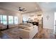 Bright living room featuring hardwood floors, large windows, and seamless flow to the kitchen at 6165 Namon Wallace Dr, Cumming, GA 30028