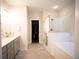 Spacious main bathroom with double vanity, glass shower, and separate soaking tub at 6165 Namon Wallace Dr, Cumming, GA 30028