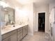 Bright bathroom featuring double vanity, large mirror, and modern fixtures at 6165 Namon Wallace Dr, Cumming, GA 30028