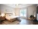 Tranquil main bedroom featuring hardwood floors, large windows, and a tray ceiling at 6165 Namon Wallace Dr, Cumming, GA 30028
