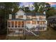 View of the back of the house, featuring a screened porch, multiple balconies, and an expansive yard at 1141 Ragley Hall Ne Rd, Brookhaven, GA 30319