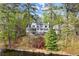 Backyard view showcasing the house with a screened porch, lush greenery, and lake access at 1141 Ragley Hall Ne Rd, Brookhaven, GA 30319
