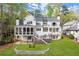 A sprawling white home featuring a screened porch and lush green lawn with trees in the background at 1141 Ragley Hall Ne Rd, Brookhaven, GA 30319