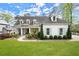 Charming white brick home featuring a manicured lawn, covered porch, and dormer windows at 1141 Ragley Hall Ne Rd, Brookhaven, GA 30319