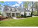 Charming white brick home featuring a manicured lawn, covered porch, and dormer windows at 1141 Ragley Hall Ne Rd, Brookhaven, GA 30319