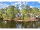 Lake view showing the house and surrounding lush greenery, creating a peaceful and scenic backdrop at 1141 Ragley Hall Ne Rd, Brookhaven, GA 30319