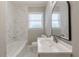 Updated bathroom showcasing marble tiling and a modern vanity with an arched mirror at 1050 N Carter Rd, Decatur, GA 30030