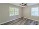 Neutral bedroom featuring hardwood flooring, two windows, modern ceiling fan, and base trim at 1050 N Carter Rd, Decatur, GA 30030