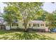Charming one-story home with white siding, black shutters, and mature landscaping at 1050 N Carter Rd, Decatur, GA 30030