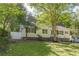 Charming one-story home with white siding, black shutters, and mature landscaping at 1050 N Carter Rd, Decatur, GA 30030