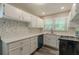 Well-lit kitchen featuring white cabinets, modern appliances, quartz countertops, and mosaic tile backsplash at 1050 N Carter Rd, Decatur, GA 30030