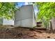 A view of a home's backyard featuring a sloped landscape with mature trees, a porch, and natural scenery at 164 Chickasaw Ln, Austell, GA 30168