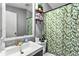 Updated bathroom with marble framed mirror, vanity and gold faucet. Shower with patterned curtain at 164 Chickasaw Ln, Austell, GA 30168
