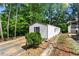 A charming single-story home with a well-manicured lawn and driveway nestled among mature trees at 164 Chickasaw Ln, Austell, GA 30168