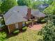 Aerial view of a well-maintained brick house with a circular brick patio and landscaped backyard at 225 Wexford Overlook Dr, Roswell, GA 30075