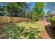 Expansive backyard with well-maintained lawn, mature trees, and privacy fence, providing a serene and private outdoor space at 225 Wexford Overlook Dr, Roswell, GA 30075