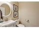 Cozy powder room featuring a modern sink, round mirror, and neutral wall color, offering a clean and functional space at 225 Wexford Overlook Dr, Roswell, GA 30075