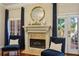 Cozy fireplace with decorative mantle, flanked by windows and seating, and access to the patio at 225 Wexford Overlook Dr, Roswell, GA 30075