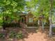 Charming brick home featuring a well-manicured lawn, mature trees, and welcoming front porch at 225 Wexford Overlook Dr, Roswell, GA 30075
