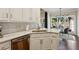 Bright kitchen with stainless steel dishwasher, white cabinetry, granite countertops, and adjacent dining area at 225 Wexford Overlook Dr, Roswell, GA 30075