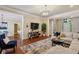 Spacious living area with hardwood floors, a large sofa, and a view of the dining area at 225 Wexford Overlook Dr, Roswell, GA 30075