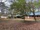 Exterior view of the home showing the backyard, detached garage, and lush greenery at 2932 Highway 20 Se, Conyers, GA 30013
