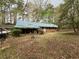 Rustic home exterior with a blue roof, a covered porch, and mature trees on a spacious lot at 2932 Highway 20 Se, Conyers, GA 30013