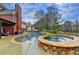 Beautiful backyard with inground pool, hot tub, patio area, and mature landscaping at 3855 Greenside Ct, Dacula, GA 30019