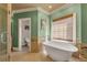 Stylish bathroom with free-standing tub next to a window and a door leading to another bathroom at 3855 Greenside Ct, Dacula, GA 30019
