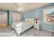 Comfortable bedroom with blue walls, neutral carpet, and a large window with natural light at 3855 Greenside Ct, Dacula, GA 30019