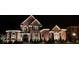 Stunning two-story brick home with manicured lawn and elegant nighttime illumination at 3855 Greenside Ct, Dacula, GA 30019