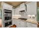 Elegant white kitchen showcasing stainless steel appliances and patterned tile backsplash at 3855 Greenside Ct, Dacula, GA 30019