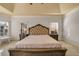Main bedroom featuring a tufted headboard, with carpeted floors and natural light at 3855 Greenside Ct, Dacula, GA 30019