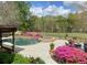 Spacious patio with lush greenery and outdoor seating overlooking the pool at 3855 Greenside Ct, Dacula, GA 30019