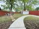 Large fenced backyard featuring a walking path, tool shed, and sitting area with Adirondack chairs at 1074 Hobson Sw St, Atlanta, GA 30310