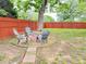 Relaxing backyard area with a red brick fire pit surrounded by three Adirondack chairs and a privacy fence at 1074 Hobson Sw St, Atlanta, GA 30310