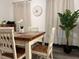 Dining room with a wooden table surrounded by white chairs, complemented by sheer curtains and a tall plant at 1074 Hobson Sw St, Atlanta, GA 30310