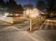 Nighttime view of a charming home featuring a new wooden fence, enhancing curb appeal and providing privacy at 1074 Hobson Sw St, Atlanta, GA 30310